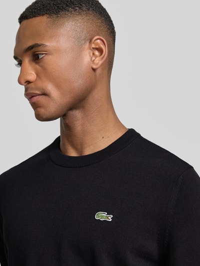 Männermodel trägt Regular Fit Strickpullover aus Baumwoll-Mix von Lacoste, Optik: Unifarben, Logo-Stitching, Nahaufnahme Oberkörper.