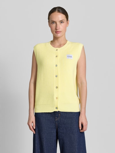 Frauenmodel trägt Regular Fit Strickweste aus Viskose-Mix Modell 'MILLA' von VILLA SOPHIE in Unifarben, Rippstrick, Label-Patch, Ganzkörperansicht von vorne.