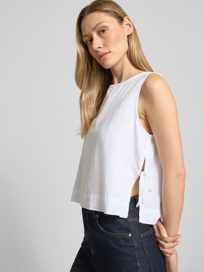 Frauenmodel trägt Blusenshirt mit seitlicher Schnürung Modell 'Svetlana' von Neo Noir, Reine Baumwolle, Lockerer-Schnitt, Rundhalsausschnitt, Rückenlänge bei Größe 36: 51 cm, weiße Farbe, glatte Struktur, Ganzkörperansicht von vorne.