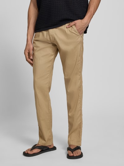 Männermodel trägt Relaxed Fit Hose aus Baumwoll-Leinen-Mix Modell 'KANE' von Jack & Jones in Beige mit elastischem Bund, Schnürung und Gesäßtaschen, Bundweite bei Größe M 42 cm, Innenbeinlänge 82 cm, Nahaufnahme Unterkörper von vorne.