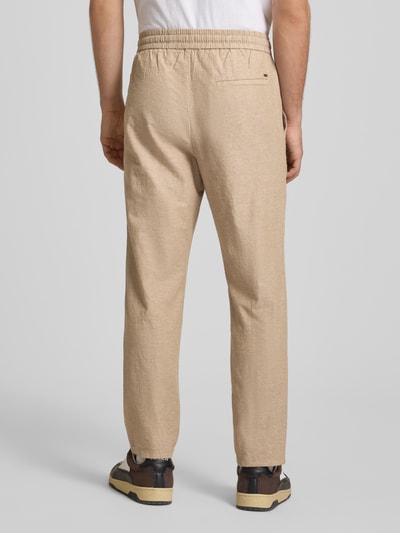 Männermodel trägt Tapered Leinenhose aus Baumwoll-Leinen-Mix Modell 'LINUS' von Only & Sons in Melange-Optik, Ganzkörperansicht Rückansicht.