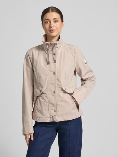 Frauenmodel trägt Regular Fit Jacke mit Logo-Patch von Gil Bret in Beige, Stehkragen, Reißverschluss, Eingrifftaschen, Ganzkörperansicht von vorne.