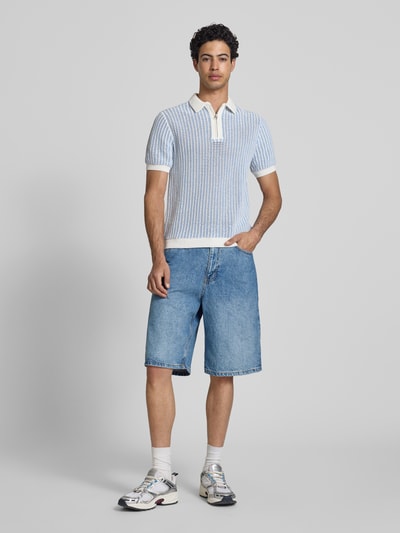 Männermodel trägt Straight Fit Shorts in Denim-Optik von REVIEW, mittleres Blau, 5-Pocket-Design aus Baumwolle, Ganzkörperansicht von vorne.