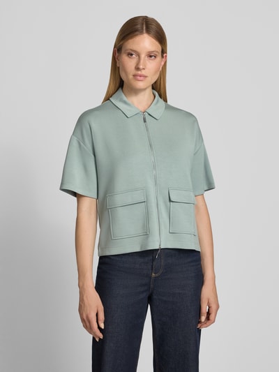 Frauenmodel trägt Jacke mit Umlegekragen von Christian Berg Woman aus Elastischer-Material-Mix mit Gerader-Schnitt, Reißverschluss, 1/2-Arm, AufgesetzteTaschen in sanftem Mintgrün, glatte Textur, Ganzkörperansicht von vorne.