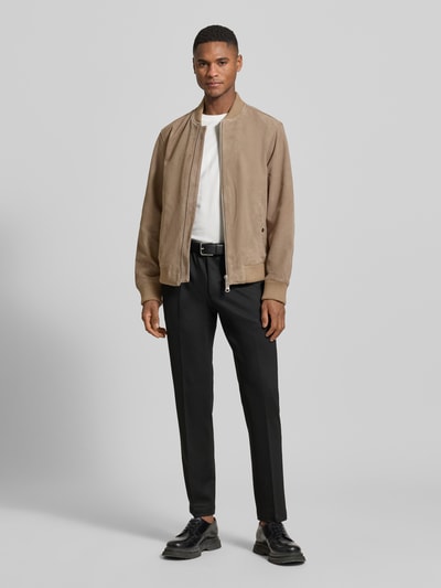 Männermodel trägt Regular Fit Wildlederjacken aus reinem Ziergenleder Modell 'ARCHIVE' von SELECTED HOMME; unifarben, College-Kragen, Ganzkörperansicht von vorne