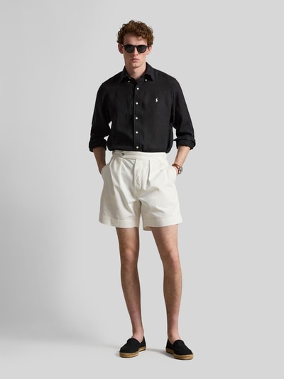 Męski model nosi Regular Fit Freizeithemd aus reinem Leinen od Polo Ralph Lauren, efekt: jednolity kolor, czarny, długi rękaw, kołnierzyk typu button down, listwa guzikowa jednorzędowa, detal z logo, pas na plecach z zakładką cacharel, sportowy mankiet, wykończenie materiału: cieniowana przędza, czyste lniane, widok całej sylwetki z przodu.