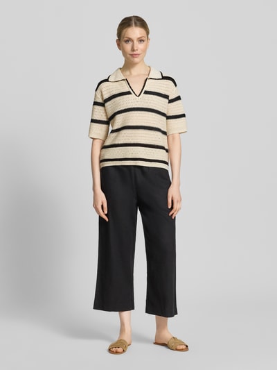Frauenmodel trägt Regular Fit Poloshirt aus Baumwoll-Mix von s.Oliver RED LABEL mit gestreiftem Allover-Muster, Strickstruktur, V-Ausschnitt, Kurzarm, Ganzkörperansicht von vorne.