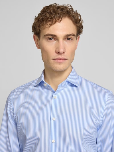 Männermodel trägt Slim Fit Business-Hemd mit Kentkragen van Jake*s, puur katoen, blauw-wit gestreept, knoopsluiting, nahaufnahme oberkörper.