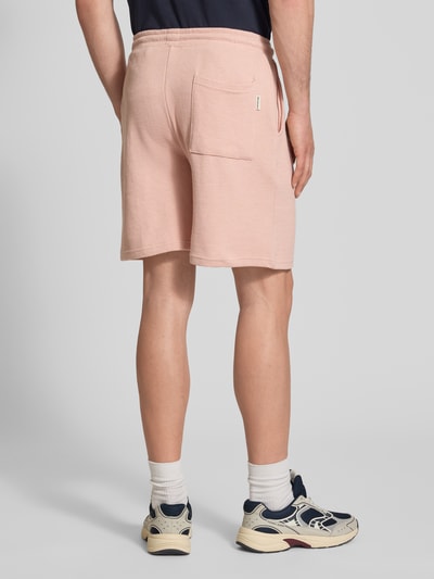 Männermodel trägt Shorts aus Baumwoll-Mix mit Strukturmuster Modell 'KNOX' von Redefined Rebel in Rosa, Relaxed-Fit, elastischer Bund mit Tunnelzug, Rückansicht, Ganzkörperansicht.