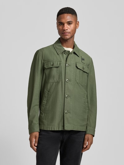 Männermodel trägt Regular Fit Hemdjacke mit Brusttaschen Modell 'Goodale' von Blauer Usa in Olivgrün, reine Baumwolle, Knopfleiste, Umlegekragen, Eingrifftaschen, Ganzkörperansicht von vorne.