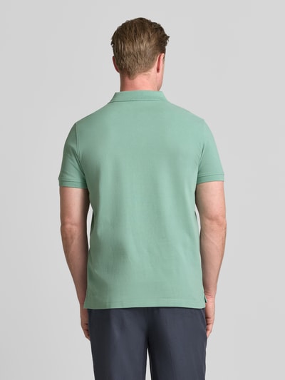 Männermodel trägt Regular Fit Poloshirt mit Label-Stitching von MCNEAL aus Reine Baumwolle in Grün, Rückenlänge 70 cm, Ganzkörperansicht Rückansicht.