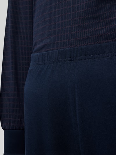 Männermodel trägt Regular Fit Pyjama-Set aus reiner Baumwolle von Schiesser, dunkle Blautöne, elastische Abschlüsse, Nahaufnahme Oberkörper
