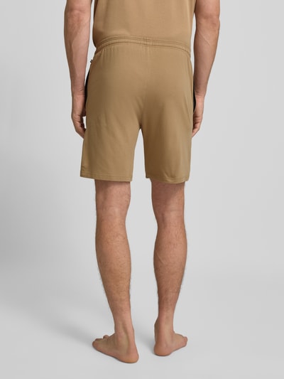 Männermodel trägt Regular Fit Sweatshorts aus Baumwoll-Mix Modell 'MIX&MATCH' von BOSS, Optik: Unifarben, Ganzkörperansicht Rückansicht.