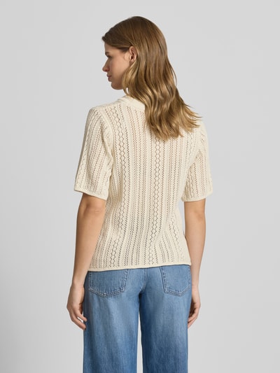 Frauenmodel trägt Regular Fit Strickshirt aus reiner Baumwolle Modell 'NUKA' von Pieces mit Lochstrick, gestreift, Allover-Muster, Kurzarm, Rückansicht.