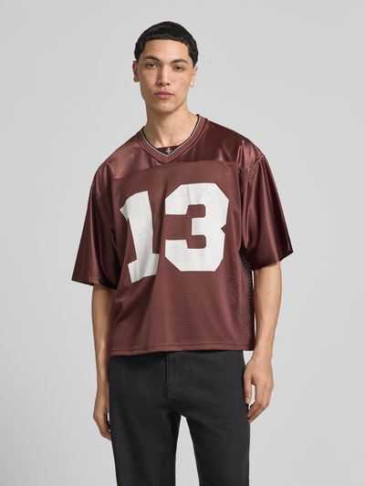 Männermodel trägt T-Shirt in semitransparenter Optik von REVIEW, lockere Passform, V-Ausschnitt, Halbarm, Rückenlänge 67 cm, Ganzkörperansicht von vorne.