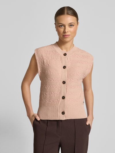 Frauenmodel trägt Strickweste mit Rundhalsausschnitt von Scotch & Soda aus Baumwoll-Mix, Slim-Fit, Knopfleiste, Ganzkörperansicht von vorne.