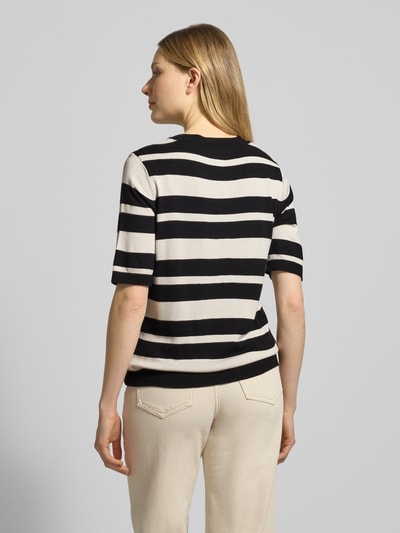 Frauenmodel trägt Strickshirt mit Rundhalsausschnitt und Label-Detail von More & More, schwarz-weiß gestreift, Regular Fit, Rückenansicht.