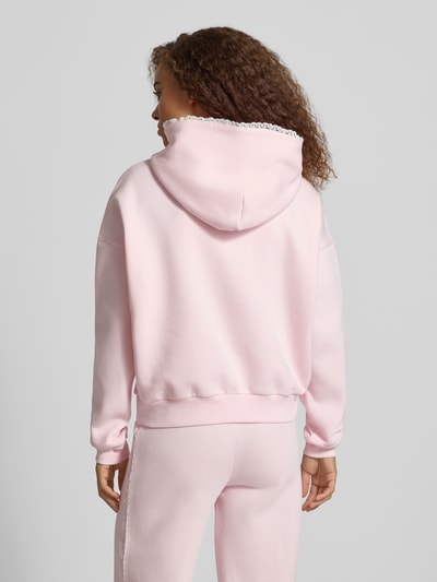 Frauenmodel trägt Hoodie mit Häkelspitzenbesatz von REVIEW in Rosa, lockere Passform, Baumwollmischung, Rückansicht, KI-modifiziertes Bild.