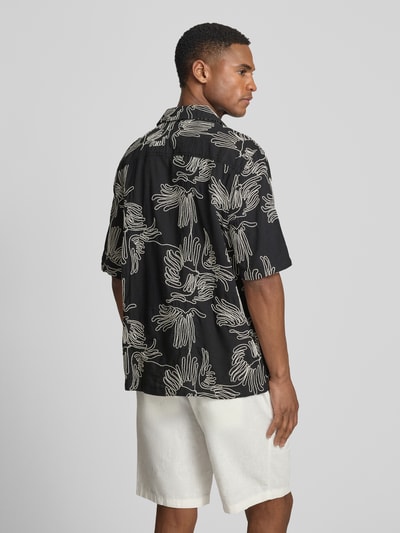 Männermodel trägt Freizeithemd mit floralem Allover-Stitching Modell 'Liam' von Les Deux in Schwarz, Baumwoll-Mix, Regular-Fit, Ganzkörperansicht Rückansicht.
