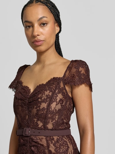 Frauenmodel trägt Midikleid mit Allover-Spitzenbesatz von Self-Portrait in Dunkelbraun, taillierte Passform, Gürtel, Nahaufnahme Oberkörper.