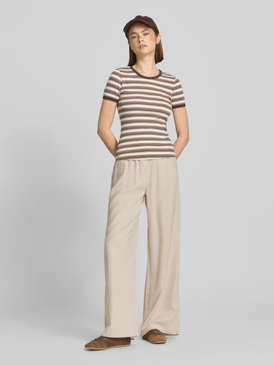 Frauenmodel trägt Regular Fit Weite Hose aus Viskose Modell 'ARIS' von Only, Animal-Print, Tunnelzug, Popeline, seitliche Eingrifftaschen, Ganzkörperansicht von vorne.