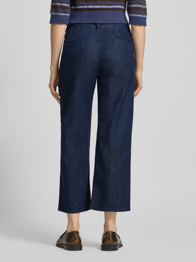 Frauenmodel trägt Wide Leg Jeans in verkürzter Passform Modell 'Maine' von Brax, dunkelblauer Baumwoll-Mix mit Stretch, Ganzkörperansicht Rückansicht.