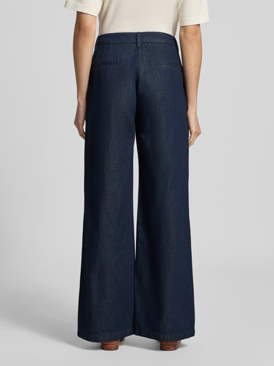 Frauenmodel trägt Wide Leg Jeans mit Lyocell-Anteil von COMMA, dunkelblauer Baumwoll-Lyocell-Mix, angedeutete Taschen, Ganzkörperansicht Rückansicht.