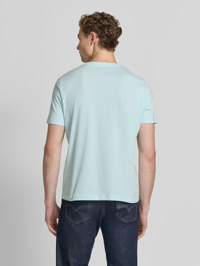 Männermodel trägt Regular Fit T-Shirt aus reiner Baumwolle von s.Oliver RED LABEL in Hellblau, glatte Baumwollstruktur, Ganzkörperansicht Rückansicht.