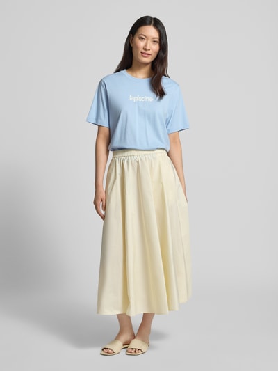 Modelka kobieca nosi Regular Fit T-Shirt aus reiner Baumwolle Modell 'MACY' von Selected Femme, jasnoniebieski, napis, krój regular fit, bawełna, widok całej sylwetki z przodu.