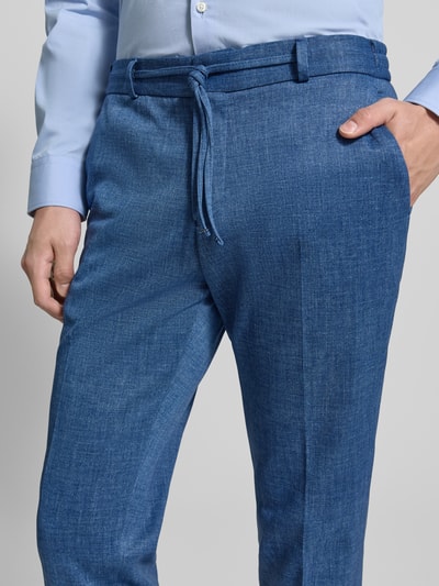 Męski model nosi Straight Fit Stoffhose mit Bundfalten Modell 'Sparta' von Zuitable, materiał z dodatkiem bawełny, niebieski, faktura gładka, szerokość w rozmiarze 50: 47 cm, długość wewnętrzna nogawki 80 cm, kieszenie z tyłu, zapięcie na guzik i zamek, z przodu, zbliżenie na górną część ciała