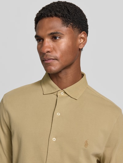 Männermodel trägt Slim Fit Freizeithemd aus reiner Baumwolle von Polo Ralph Lauren in Beige, glatte Textur, Nahaufnahme Oberkörper, Herren Freizeithemd von Polo Ralph Lauren.