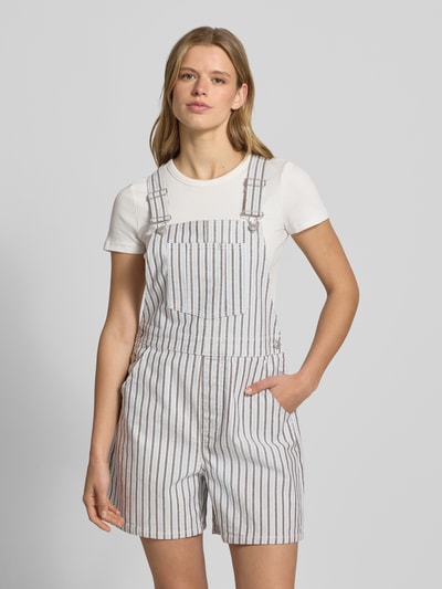 Frauenmodel trägt Regular Fit Latzhose aus Baumwoll-Mix Modell 'BILLO' von Pieces in gestreifter Denim-Optik mit 2-Knopf-Verschluss, Twill-Materialverarbeitung und aufgesetzter Brusttasche, Ganzkörperansicht von vorne.