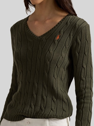Frauenmodel trägt Regular Fit Strickpullover aus Woll-Kaschmir-Mix von Polo Ralph Lauren in Olivegrün mit Zopfmuster, Nahaufnahme Oberkörper.
