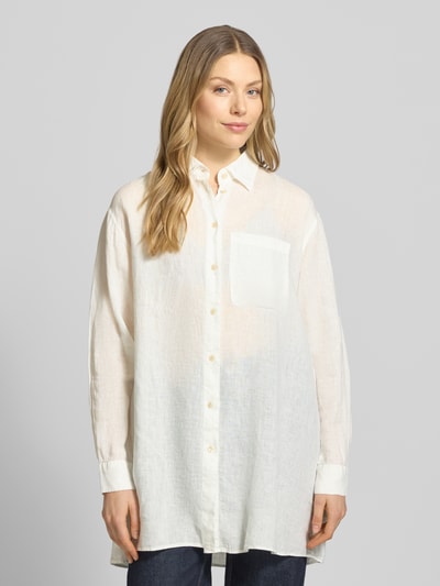 Frauenmodel trägt Relaxed Fit Longbluse aus Leinen Modell 'TAHIA' von 0039 Italy in Weiß mit Hemdblusenkragen, Knopfleiste, Brusttasche, Rückenlänge 86 cm, Ärmellänge 58 cm, Ganzkörperansicht von vorne.
