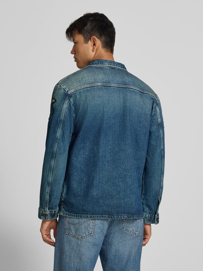 Männermodel trägt Regular Fit Jeansjacke aus Baumwoll-Mix von Replay mit Allover-Patches, mittleres Blau, Ganzkörperansicht Rückansicht.
