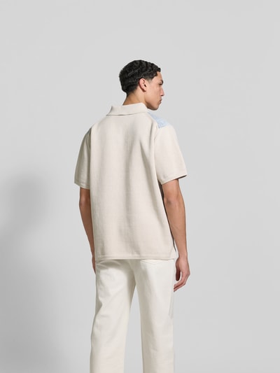 Männermodel trägt Regular Fit Poloshirt aus Baumwolle von Dsquared2 in Beige mit Jeansbesatz, Kurzarm, Rückenlänge 76 cm, Ganzkörperansicht Rückansicht.