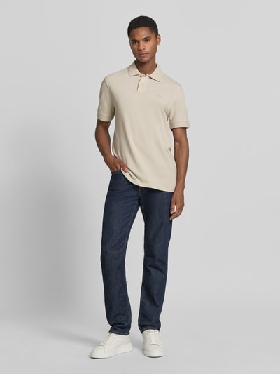 Męski model nosi Regular Fit Poloshirt aus reiner Baumwolle Modell 'PRIME' von BOSS Orange, efekt: jednolity kolor, krój regular fit, naszywka z logo, kołnierzyk polo, dekolt w serek, krótkie zapięcie na guziki, krótki rękaw, zakończenie rękawów: prążkowane, wykończenie materiału: pika, materiał: czysta bawełna; Ganzkörperansicht von vorne.