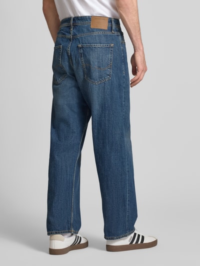 Männermodel trägt gerade geschnittene Straight Fit Jeans aus Baumwolle Modell 'ALEX ORIGINAL' von Jack & Jones in Mittelblau, 5-Pocket-Design, Rückansicht.