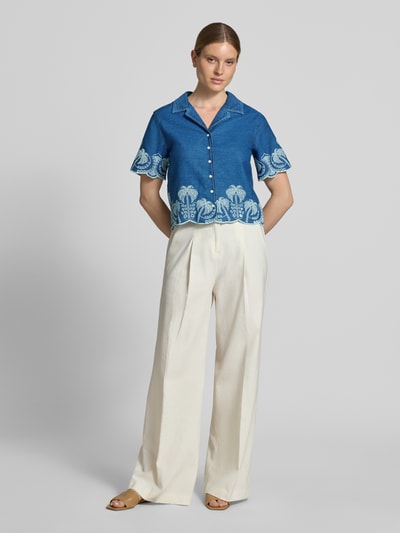 Frauenmodel trägt Regular-Fit Bluse mit Stitchings Modell 'PETRA' von Guess in Blau mit weißem Muster, Reverskragen, Knopfleiste, Ganzkörperansicht von vorne. Rückenlänge bei Größe S: 55 cm, Ärmellänge bei Größe S: 24 cm.