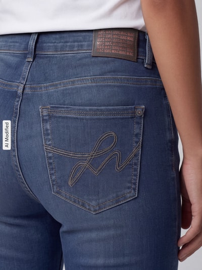 Frauenmodel trägt Straight Fit Jeans aus Baumwoll-Mix Modell 'Carrie' von MAC in Blau mit auffälliger Gesäßtaschenstickerei, Nahaufnahme Rückansicht, Damen Straight Fit Jeans von MAC, KI-modifiziertes Bild.