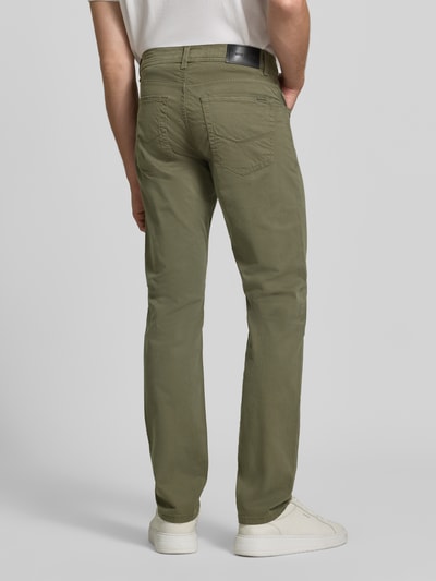 Mężczyzna nosi Straight Fit Jeans aus elastischem Baumwoll-Mix Modell 'Lyon' von Pierre Cardin w kolorze khaki, 5 kieszeni, szlufki na pasek, zapięcie na guzik i zamek błyskawiczny, Szerokość w rozmiarze 32/34: 41 cm, Długość wewnętrzna nogawki: 86 cm, mieszanka bawełny i elastanu, Ganzkörperansicht Rückansicht.
