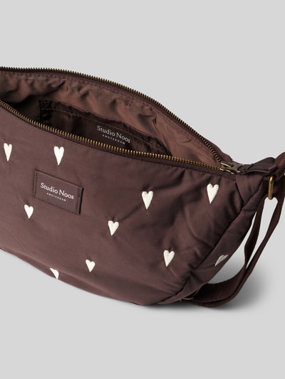 Produktfoto, Fanny Pack mit Logo-Detail Modell 'Puffy' von Studio Noos, brauner Stoff mit weißen Herz-Stickereien, Reißverschluss, textiler Struktur