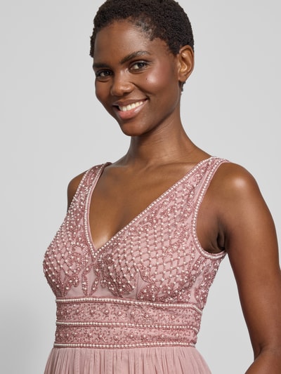 Frauenmodel trägt Abendkleid mit Perlen- und Ziersteinbesatz von Lace & Beads im Material-Mix, V-Ausschnitt, tailliertem Schnitt, Maxilänge, Nahaufnahme Oberkörper.