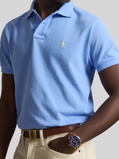 Männermodel trägt Regular Fit Poloshirt aus reiner Baumwolle von Polo Ralph Lauren in Hellblau mit Logo-Detail, Nahaufnahme Oberkörper.