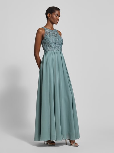 Frauenmodel trägt Abendkleid mit Strasssteinen von LAONA in Blaugrün aus Tüll mit floraler Spitze, taillierter Schnitt, Ganzkörperansicht von vorne.