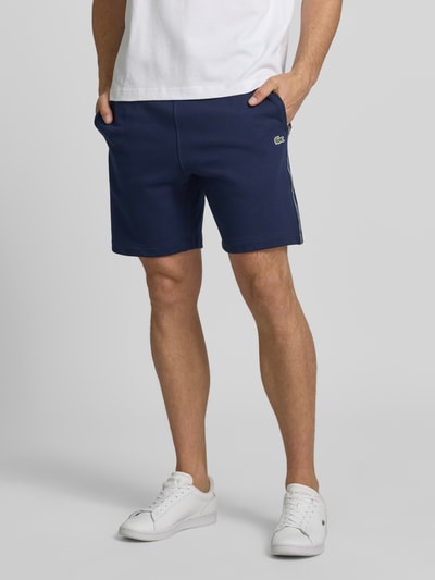 Männermodel trägt Regular Fit Sweatshorts aus reiner Baumwolle von Lacoste, Optik: Unifarben, 5-Pocket-Design, Sweat, Nahaufnahme Unterkörper.
