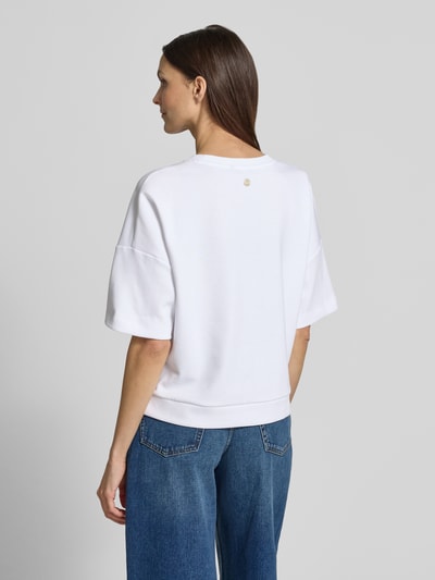 Modelka nosi damski t-shirt Boxy Fit T-Shirt Modell 'Tilina' od JOOP!, mieszanka bawełny, okrągły dekolt, widok całej sylwetki z tyłu.