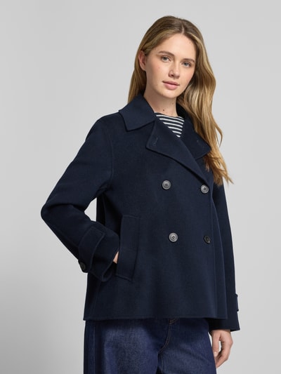 Modelka kobieca nosi granatowy Loose Fit Wollmantel aus Schurwoll-Mix Modell 'FANTINO' od Weekend Max Mara, z dwurzędowym zapięciem, długimi rękawami i bocznymi kieszeniami; widok na cały tułów z przodu.