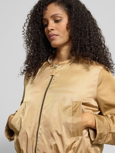 Frauenmodel trägt Daunenjacke mit Eingrifftaschen von Luisa Cerano in Gold, Daunen-Federn-Füllung, Relaxed-Fit, Nahaufnahme Oberkörper.