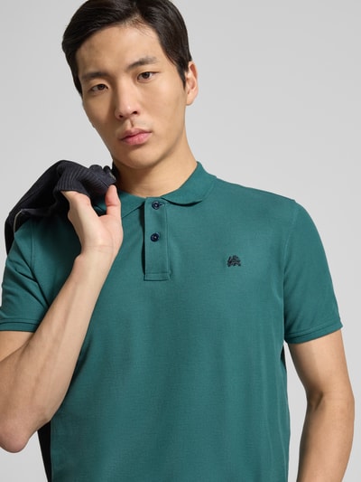 Männermodel trägt Poloshirt mit Logo-Stitching Modell 'PERFORMANCE' von Lerros in Grün, Baumwoll-Mix, Nahaufnahme Oberkörper.